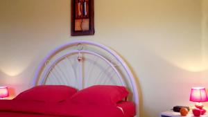 een slaapkamer met een rood bed met 2 rode kussens bij Appartement de 2 chambres avec vue sur la mer jardin clos et wifi a Le Vauclin in Le Vauclin