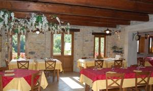 a dining room with tables with red and yellow table cloth at Agriturismo Spino Fiorito in Casola in Lunigiana