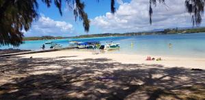 a beach with boats and people in the water at Charming house in Mahebourg with sea view and garden in Mahébourg