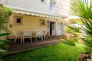 ヴィラモウラにある3 bedrooms house with shared pool enclosed garden and wifi at Vilamoura 3 km away from the beachの庭園(テーブル、椅子付)