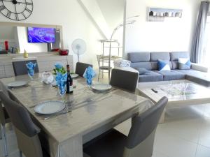 - une salle à manger avec une table, des chaises et un canapé dans l'établissement Appartement de 2 chambres avec vue sur la mer et balcon amenage a Berck, à Berck-sur-Mer