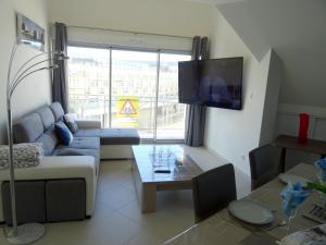 ein Wohnzimmer mit einem Sofa und einem Tisch in der Unterkunft Appartement de 2 chambres avec vue sur la mer et balcon amenage a Berck in Berck-sur-Mer