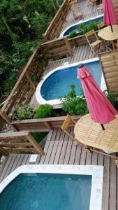 a wooden deck with a pool and chairs and a hammock at Maison d'une chambre avec piscine privee jacuzzi et jardin clos a Le Moule in Le Moule