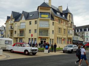 une vieille voiture garée devant un bâtiment dans l'établissement Appartement de 2 chambres avec vue sur la mer et balcon amenage a Berck, à Berck-sur-Mer