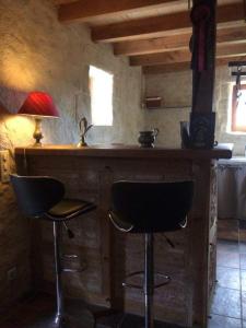 a bar with two chairs and a table with a lamp at Studio charmant à Bio avec jardin et piscine partagée, 32 m². in Bio