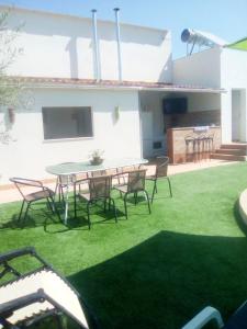un patio con tavolo e sedie in un cortile di 4 bedrooms house with private pool enclosed garden and wifi at Montilla Cordoba a Jarata
