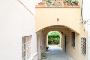 eine Gasse zwischen zwei Gebäuden mit Topfpflanzen auf dem Dach in der Unterkunft Refined Apartment in Lastra a Signa - 77 sqm - Air Conditioning in Lastra a Signa
