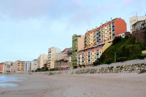 uma vista para uma praia com edifícios e condomínios em 5 bedrooms apartement at Malpica 10 m away from the beach with sea view furnished terrace and wifi em Malpica de Bergantiños