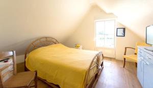 a bedroom with a yellow bed and a window at Maison de 3 chambres avec jardin amenage et wifi a Ruille sur Loir in Ruillé-sur-Loir