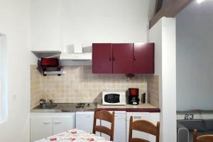 a kitchen with red cabinets and a table with chairs at Maison de 3 chambres avec jardin clos et wifi a Edruchon in Saint-Martin-au-Bosc