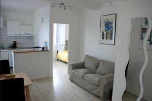 a living room with a couch and a kitchen at Appartement moderne à Rosny-sous-Bois, 38 m² avec vue in Rosny-sous-Bois