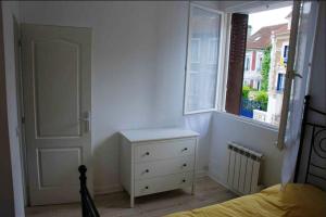 a bedroom with a bed and a window and a dresser at Appartement moderne à Rosny-sous-Bois, 38 m² avec vue in Rosny-sous-Bois