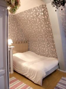 ein Schlafzimmer mit einem Bett mit floralen Akzenten in der Unterkunft Maison de charme à Berville avec jardin non clôturé in Berville