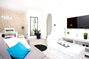 a living room with a white couch and a flat screen tv at Modern Apartment in Trogir - 70 m² - Parking Included in Trogir