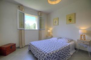 a white bedroom with a bed and two windows at Appartement de 2 chambres avec jardin clos et wifi a Taglio Isolaccio in Taglio-Isolaccio