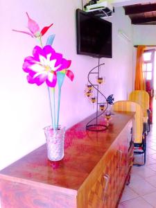 een tafel met een vaas met bloemen erop bij Appartement d'une chambre avec jardin clos et wifi a Le Robert a 2 km de la plage in Le Robert