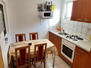 a kitchen with a table with chairs and a microwave at 2 bedrooms appartement at Pag 100 m away from the beach with sea view enclosed garden and wifi in Pag