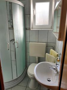 a bathroom with a toilet and a sink and a window at 2 bedrooms appartement at Pag 100 m away from the beach with sea view enclosed garden and wifi in Pag