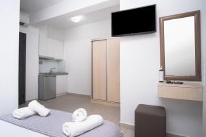 een kamer met handdoeken op een bed en een flatscreen-tv bij Atoli Studios in Skala Marion
