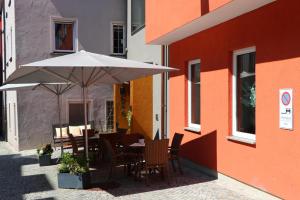 a table with an umbrella next to a building at Ochsen Hotel Am Mehlsack in Ravensburg