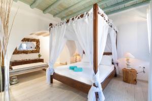 
a large bed with a canopy over it at 6 bedrooms villa at Mikonos 600 m away from the beach with sea view private pool and furnished garden in Kalo Livadi
