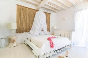 
a bed room with a white bedspread and pillows at 6 bedrooms villa at Mikonos 600 m away from the beach with sea view private pool and furnished garden in Kalo Livadi
