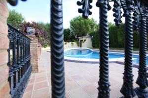 a pool seen through a wrought iron fence at Spacious Villa with Pool in Sanlúcar la Mayor in Sanlúcar la Mayor