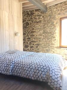 1 dormitorio con 1 cama en una pared de piedra en Chalet de 4 chambres avec terrasse amenagee a Ascou a 3 km des pistes, en Ascou