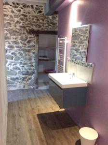 baño con lavabo y pared de piedra en Chalet de 4 chambres avec terrasse amenagee a Ascou a 3 km des pistes, en Ascou