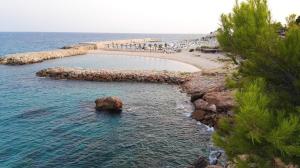 a pool in the water next to a beach at Seaside Villa in Calafat with Private Pool. in Calafat