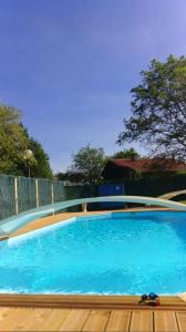 a large blue swimming pool with a wooden deck at Villa en pleine nature à Escource avec piscine privée in Escource +12 photos