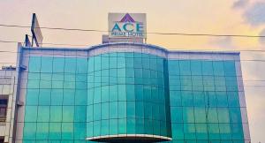 un edificio di vetro con un cartello sopra di Ace Prime Hotel a Greater Noida