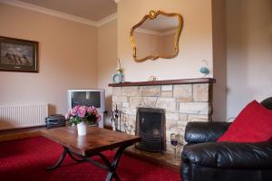 ein Wohnzimmer mit einem Kamin und einem Tisch in der Unterkunft Inviting 4-Bed House in Strokestown in Grange