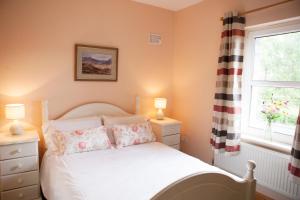 1 dormitorio con cama blanca y ventana en Inviting 4-Bed House in Strokestown, en Grange