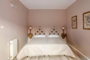ein Schlafzimmer mit einem großen weißen Bett mit zwei Lampen in der Unterkunft Realkasa Clavature Apartment in Bologna
