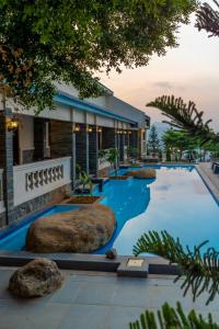 a swimming pool with rocks in front of a building at Hidden Valley Hills in Cilalawi