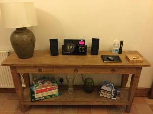 a wooden table with a radio and speakers on it at Swallow Barn at Millfields Farm Cottages in Ashbourne
