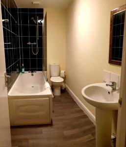 y baño con bañera, aseo y lavamanos. en Balcony Apartment near Skegness Beach & Town en Skegness