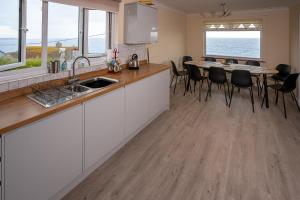 a kitchen with a sink and a table with chairs at 5-bedroom Detached House with Amazing Sea Views in Porthleven