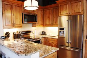 a kitchen with wooden cabinets and a stainless steel refrigerator at Vail Racquet Club Mountain Resort in Vail