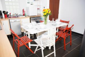 a kitchen with a white table and red chairs at The Neuk Anstruther - Sleeps 6 - Dogs Welcome in Anstruther