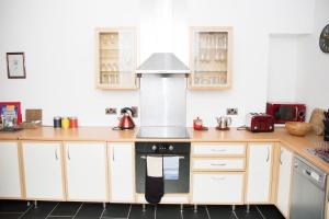 a kitchen with white cabinets and a stove top oven at The Neuk Anstruther Sleeps 6 Fantastic Location in Anstruther