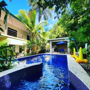 una piscina con un tobogán en un patio trasero en La Posada Jungle Hotel en Manuel Antonio