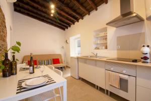 uma cozinha com armários brancos e uma mesa com um lavatório em Recanto do Alqueva em Monsaraz