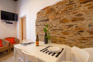 a dining room with a table and a stone wall at Recanto do Alqueva in Monsaraz