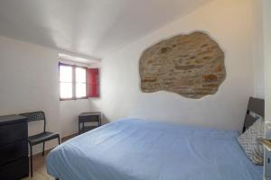 a bedroom with a bed and a rock on the wall at Recanto do Sossego in Monsaraz