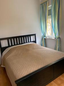 - une chambre avec un lit doté de rideaux bleus et d'une fenêtre dans l'établissement Apartment Elli, à Augsbourg