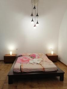 un letto in una stanza con due luci sopra di La casa di Piera a Riccò del Golfo di Spezia