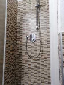 a shower with a hose attached to a tiled wall at La casa di Piera in Riccò del Golfo di Spezia