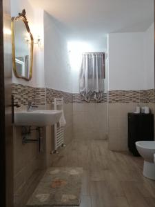 a bathroom with a sink and a toilet and a mirror at La casa di Piera in Riccò del Golfo di Spezia